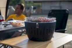 LotusGrill XL Hybrid Houtskoolbarbecue - Rood 22 LotusGrill XL Hybrid Houtskoolbarbecue - Rood -Bo-Camp Winkel lotusgrill in gebruik met toppy shirtje 2